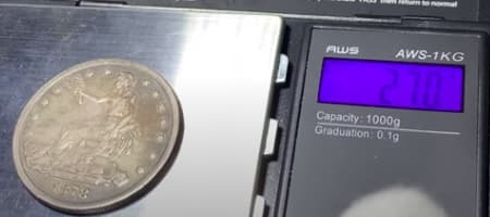 Digital scale reading a genuine Trade Dollar at 27.0 g